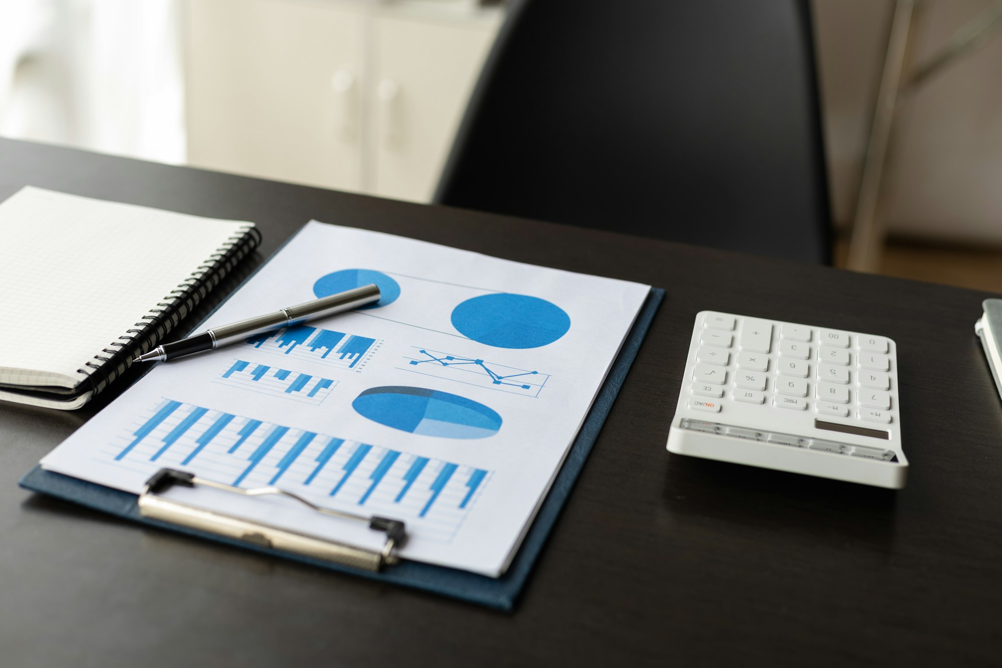 Analytical documents, business finance charts and calculators on the desk.